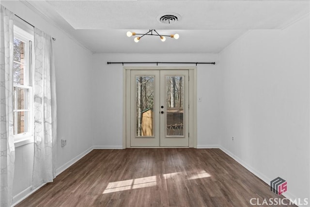 empty room featuring french doors, a chandelier, and dark hardwood / wood-style floors