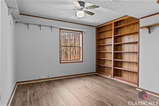 unfurnished room with hardwood / wood-style floors, ceiling fan, and crown molding