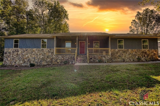 single story home with a yard and a porch