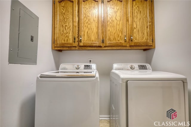 laundry area featuring electric panel, cabinets, and separate washer and dryer