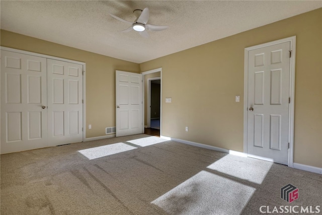 unfurnished bedroom featuring a closet, a textured ceiling, ceiling fan, and carpet