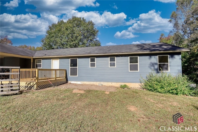 rear view of house with a lawn and a deck