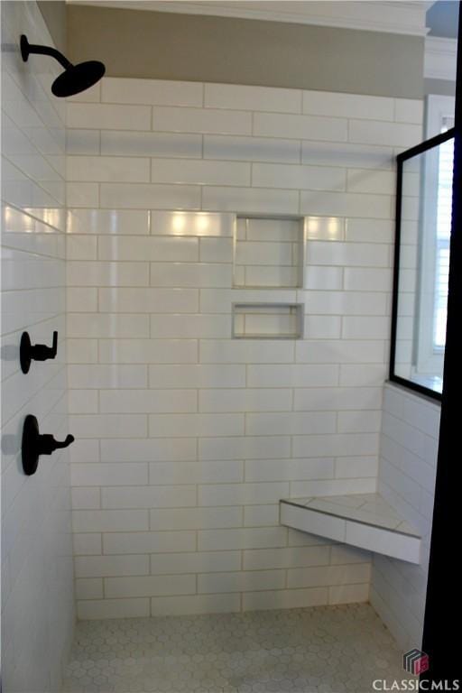 bathroom featuring tiled shower and crown molding