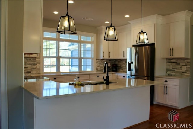 kitchen featuring white cabinets, decorative light fixtures, backsplash, and stainless steel refrigerator with ice dispenser