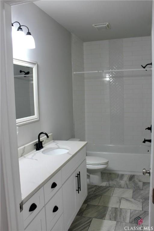 full bathroom with toilet, tiled shower / bath combo, and vanity