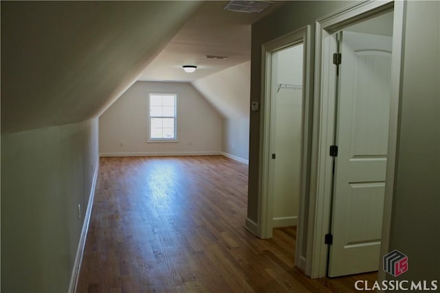 additional living space featuring lofted ceiling and dark hardwood / wood-style floors