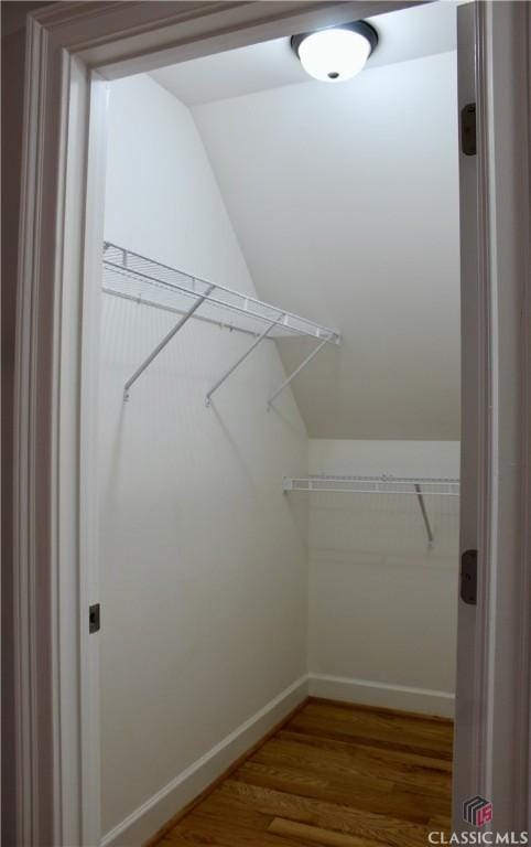 walk in closet featuring lofted ceiling and hardwood / wood-style flooring