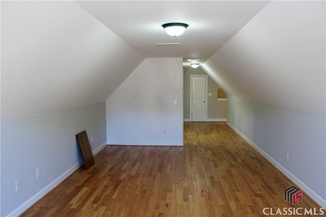 additional living space featuring lofted ceiling and dark wood-type flooring