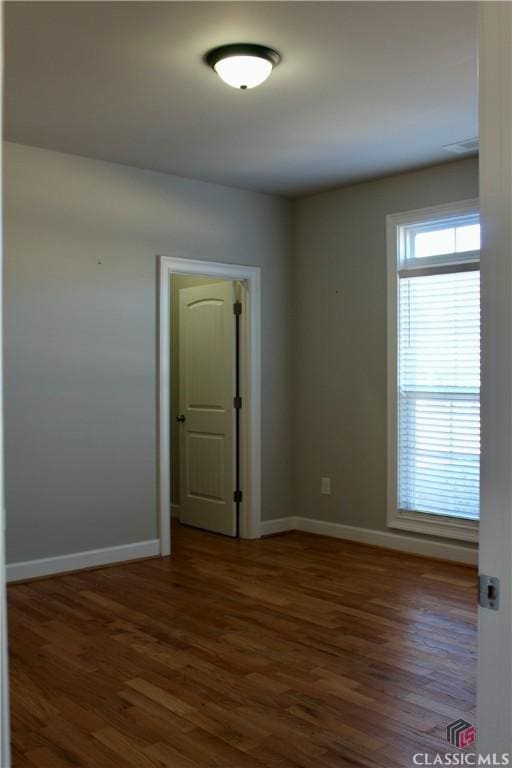 unfurnished room with dark wood-type flooring