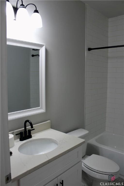 full bathroom featuring toilet, tiled shower / bath, and vanity