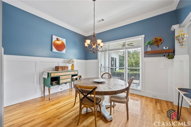 dining area featuring a chandelier, wood-type flooring, and ornamental molding