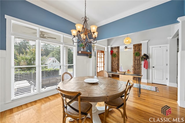 dining area with wood-type flooring, ceiling fan with notable chandelier, and crown molding