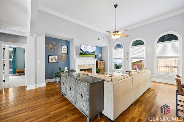 living room featuring ceiling fan, wood-type flooring, and crown molding