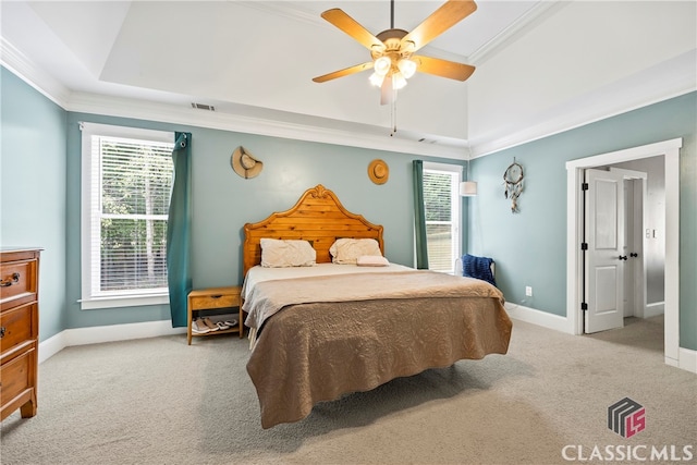 bedroom with a raised ceiling, ceiling fan, light carpet, and ornamental molding