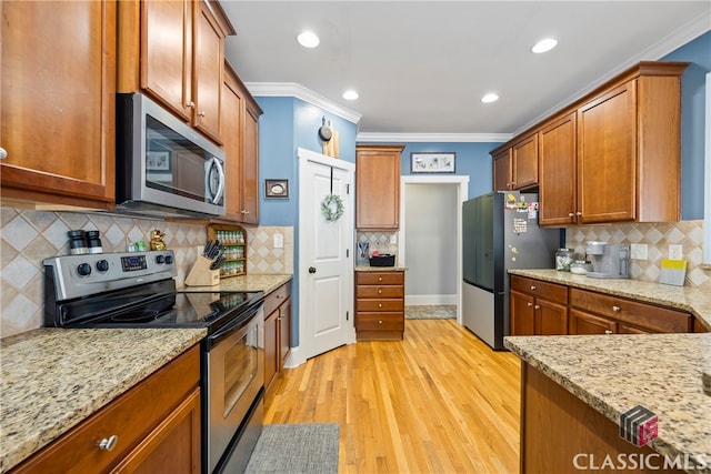 kitchen featuring light stone counters, crown molding, light hardwood / wood-style flooring, and stainless steel appliances