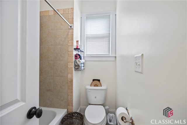 bathroom featuring toilet and tiled shower / bath combo