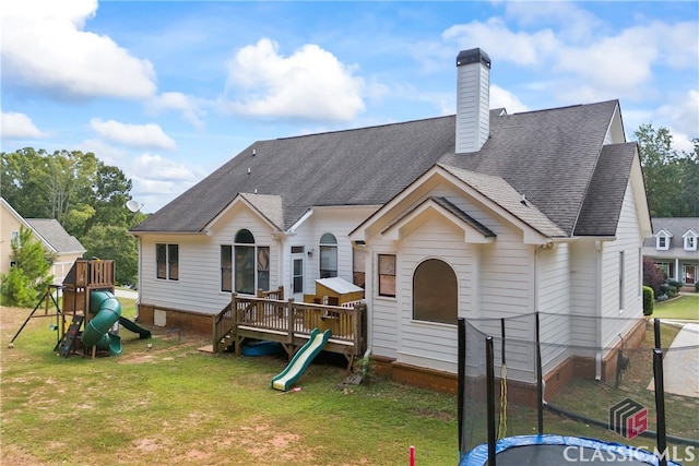 view of front of property featuring a front lawn, a wooden deck, and a playground