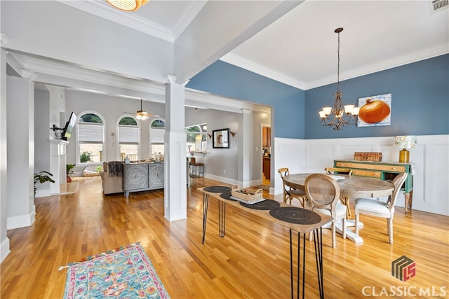 dining room with ceiling fan with notable chandelier, hardwood / wood-style floors, ornamental molding, and ornate columns