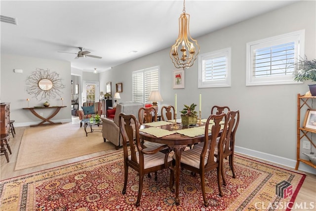 dining area featuring ceiling fan with notable chandelier and light hardwood / wood-style flooring