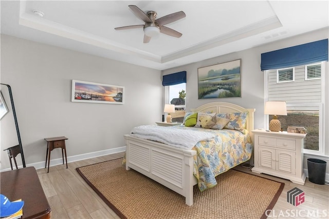 bedroom with ceiling fan and a tray ceiling