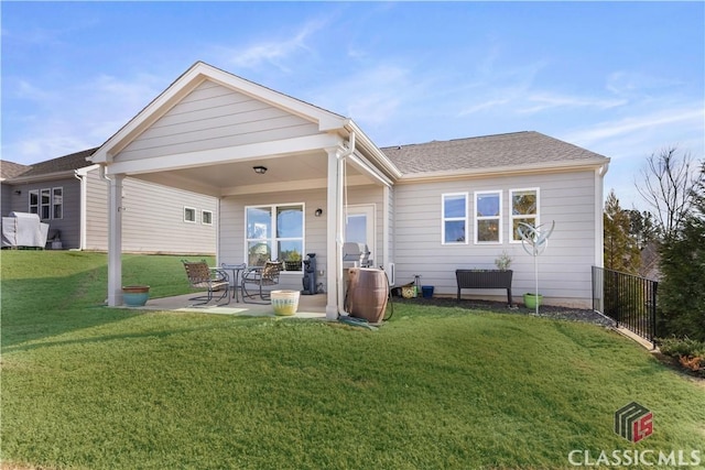 rear view of house with a lawn and a patio area