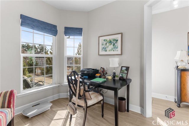 home office featuring light wood-type flooring and a healthy amount of sunlight