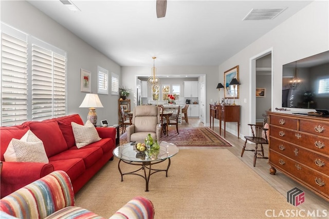 living room featuring a notable chandelier and light hardwood / wood-style flooring