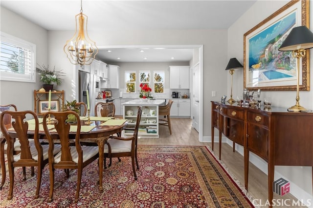 dining area with a chandelier and light wood-type flooring