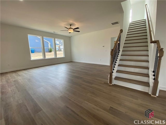 unfurnished living room featuring ceiling fan and dark hardwood / wood-style flooring