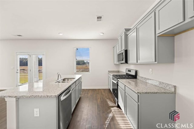 kitchen featuring light stone countertops, sink, stainless steel appliances, and plenty of natural light