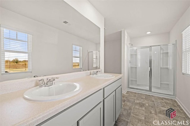 bathroom featuring a shower with shower door and vanity