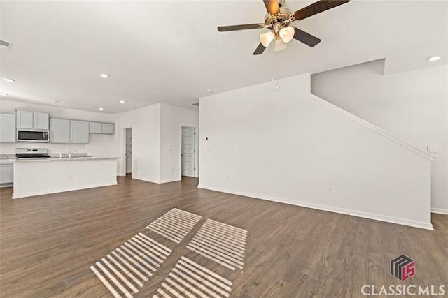 unfurnished living room with ceiling fan and dark hardwood / wood-style floors