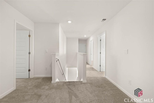 hallway featuring light colored carpet