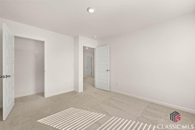 unfurnished bedroom with a closet and light carpet