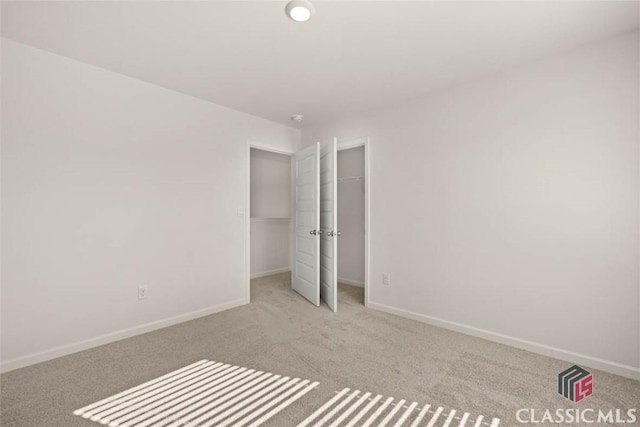 unfurnished bedroom featuring light carpet and a closet