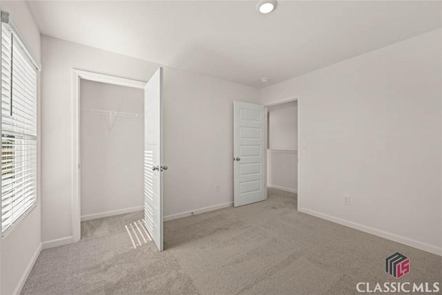 unfurnished bedroom with light carpet and a closet