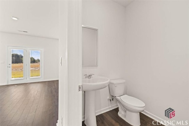 bathroom featuring sink, hardwood / wood-style floors, and toilet