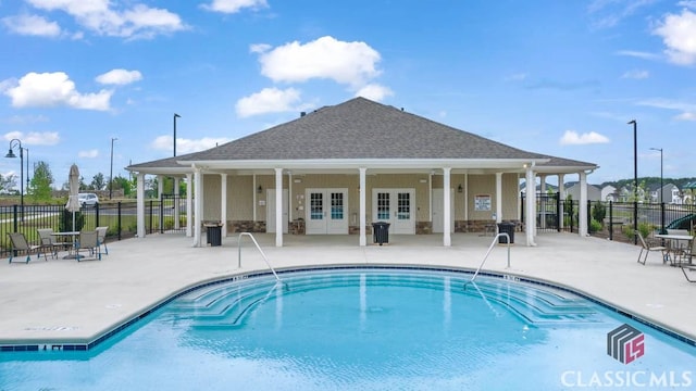 view of pool with french doors and a patio