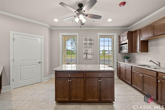 kitchen featuring stainless steel microwave and dark brown cabinets