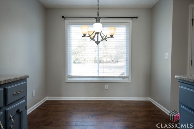 unfurnished dining area featuring plenty of natural light, dark hardwood / wood-style flooring, and a chandelier