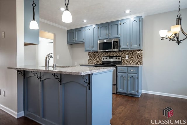 kitchen with a breakfast bar, kitchen peninsula, sink, hanging light fixtures, and appliances with stainless steel finishes