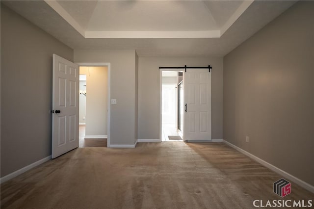 interior space featuring a barn door and a tray ceiling