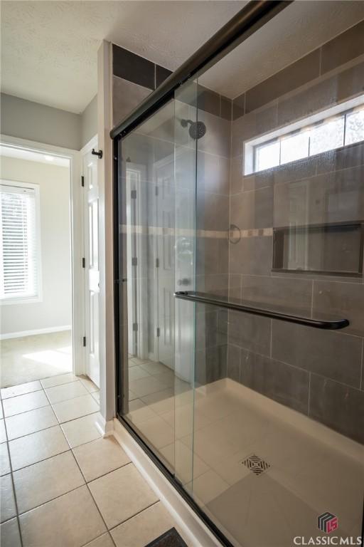 bathroom with tile patterned floors and a shower with shower door