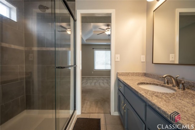 bathroom with ceiling fan, tile patterned flooring, walk in shower, and vanity