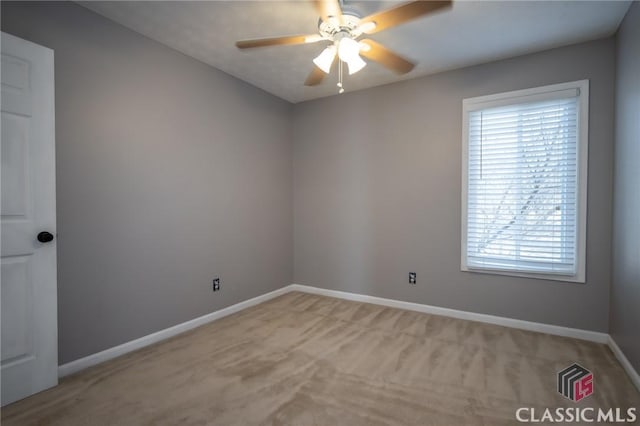 carpeted spare room with ceiling fan