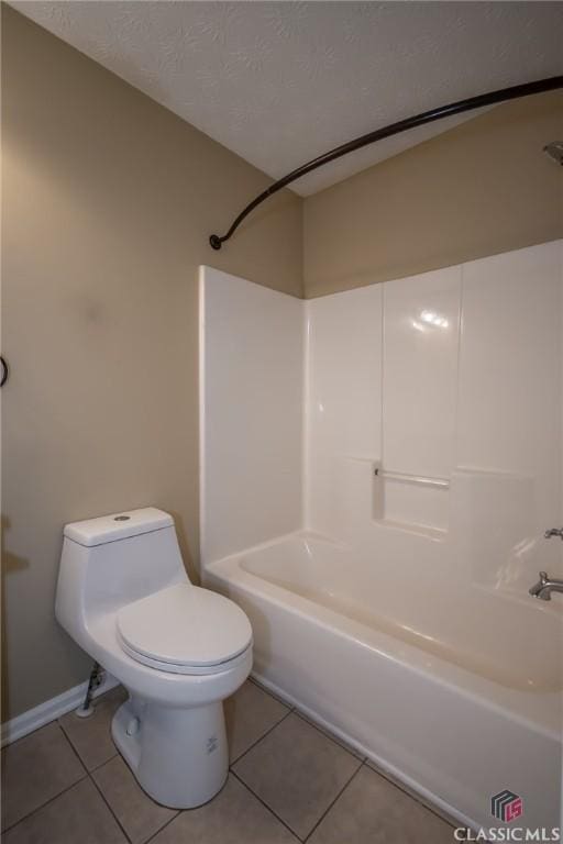 bathroom featuring tub / shower combination, a textured ceiling, toilet, and tile patterned flooring