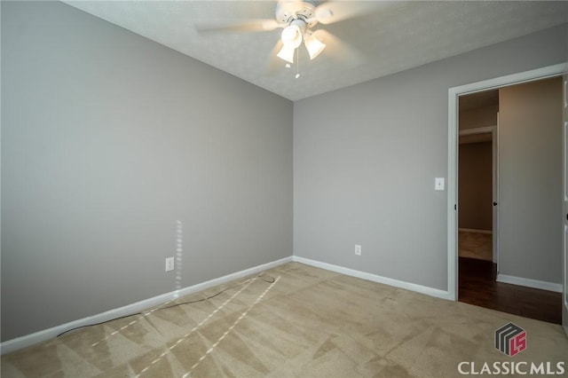 carpeted spare room featuring ceiling fan