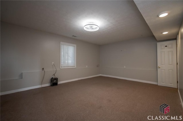 carpeted spare room featuring a textured ceiling