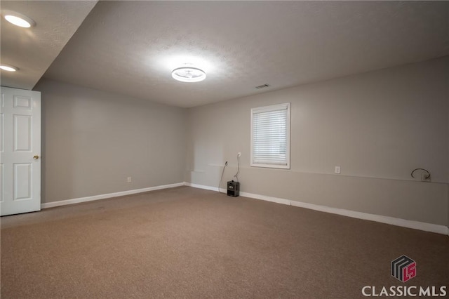 carpeted empty room featuring a textured ceiling