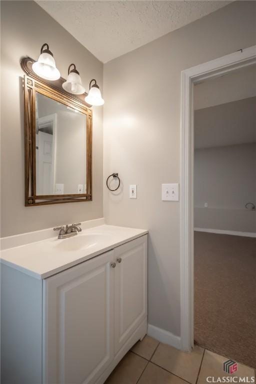 bathroom featuring vanity, tile patterned floors, and a textured ceiling